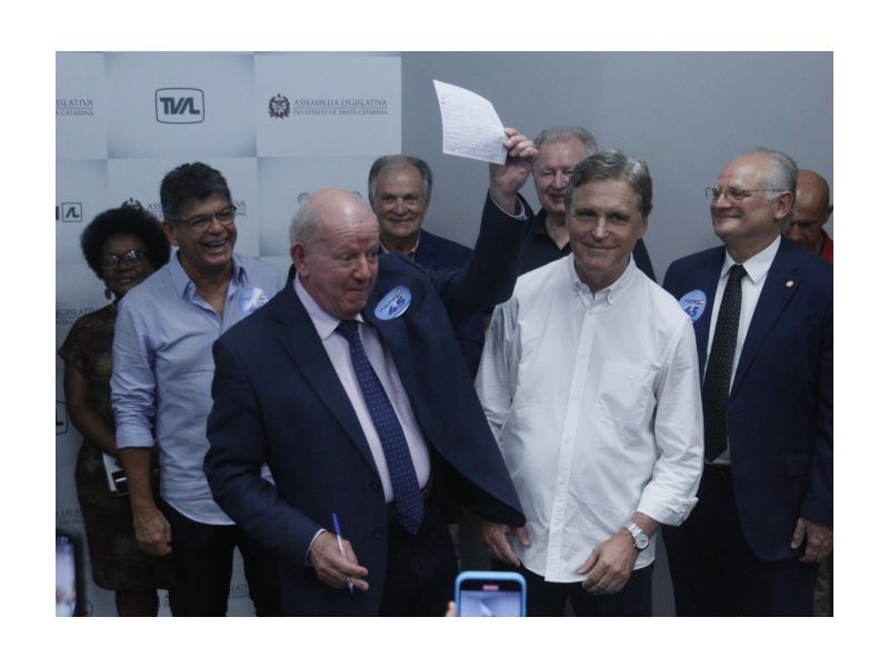 Marcos Vieira levanta ficha assinada por Dário Berger, comemorando a volta do ex-prefeito e ex-senador ao partido