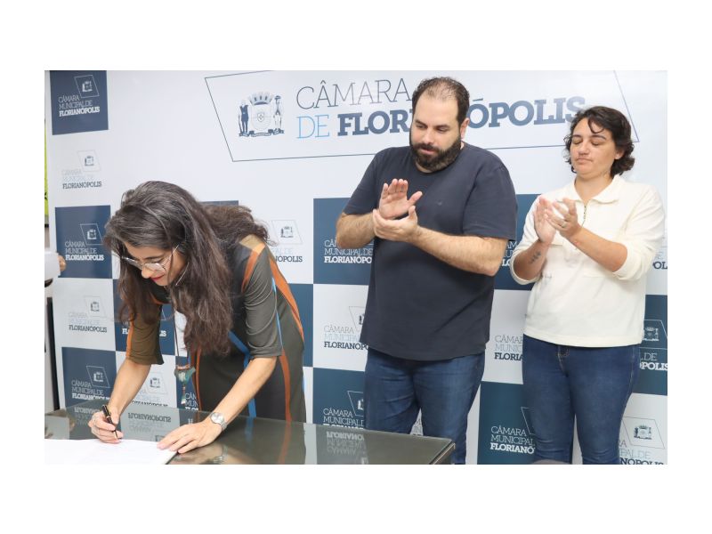 Elenira Vilela assina a posse como vereadora sob olhar de João Cobalchini e Carla Ayres