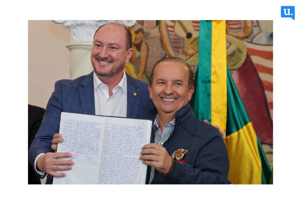 Mauro de Nadal e Jorginho Mello seguram livro que registra posses de governadores de Santa Catarina