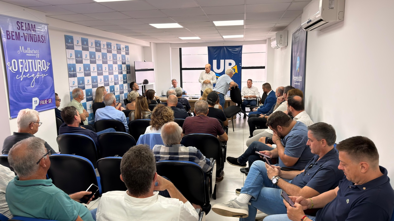 Na reunião do PP, Zé Milton discursa enquanto Aldo Rosa mexe a cadeira. Amin já havia saído sem manifestar apoio a Jorginho ou João Rodrigues.