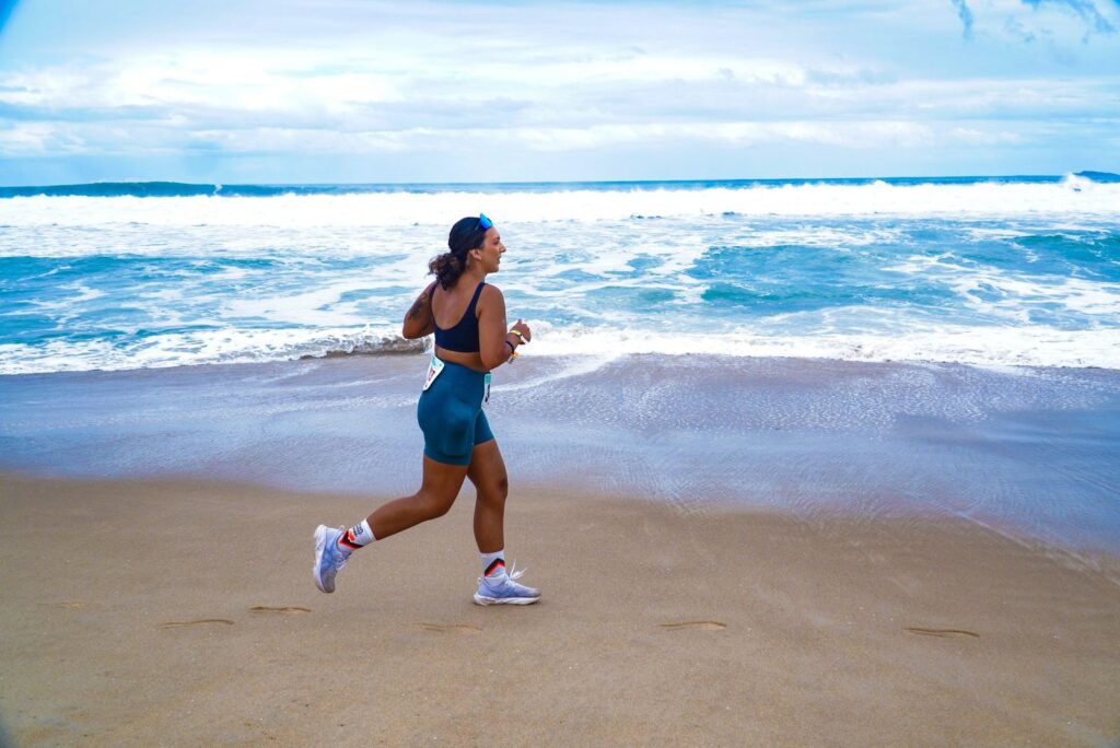 Mulher praticando corrida na beira da praia em Florianópolis